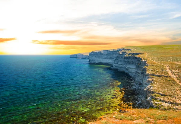 夏海湾シーン 夕日でエメラルド色の海と岩の海岸 — ストック写真