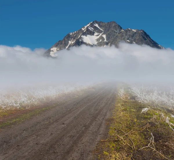 草原地面农村道路在一个密集的云高山 — 图库照片