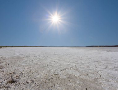 sıcak bir ışıltı güneş altında kuru çatlak tuzlu arazi