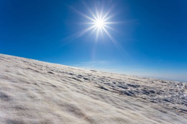 bir Parıltılı güneşin altında kar bağlı montaj yamacı