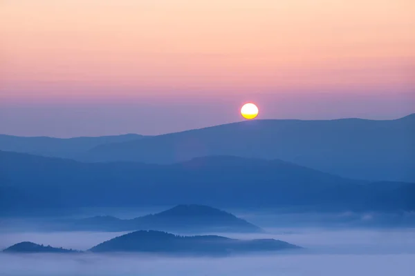 日の出の霧の中で美しい青い山の尾根のシルエット 平和な自然の背景 — ストック写真