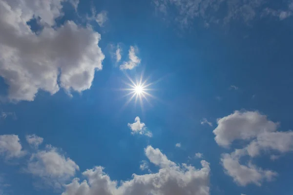 sparkle sun shining on the blue cloudy sky, summer natural background