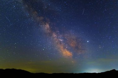 Yıldızlı bir gökyüzünün altında samanyolu ile gece çayırı