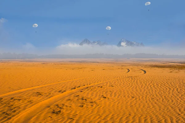 paratroopers fly over the sand desert and mountain range