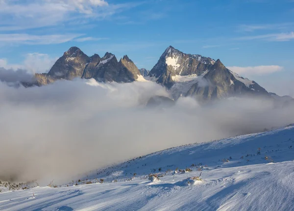 雪と密な雲の中の高い山 冬の山の風景 — ストック写真