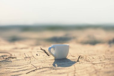 sabahın erken saatlerinde kum üzerinde closeup cofee fincan, açık kamp arka plan için iyi