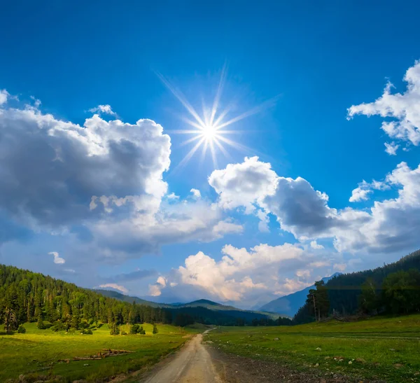 Земляна Дорога Через Зелену Гірську Долину Під Іскровим Сонцем Фоном — стокове фото