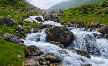 Nehir yeşil bir dağ kanyonuna doğru akıyor, açık havada yolculuk sahnesi.