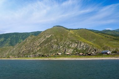Zümrüt nehir kıyısında küçük bir köy, kırsal bir arazi.