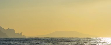 Gün doğumunda kayalık sahilli deniz koyunda, açık havada şafak vakti doğal arka plan