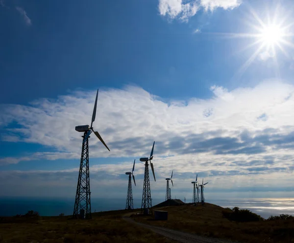 wind power station silhouette on a blue sky background