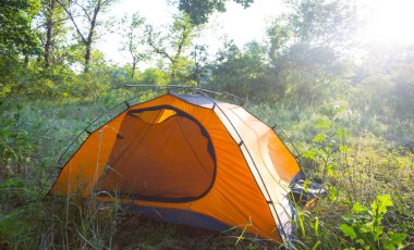 Ormanın ortasında turistik turistik bir çadır güneş ışığı altında, akşam seyahati sahnesi