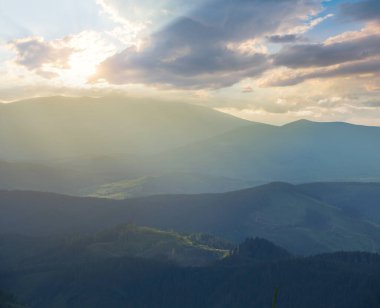 Gün batımında mavi bir sis içinde dağ sırtı, doğal seyahat arka planı.