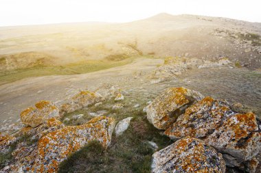 Gün batımında büyük taşlarla çayır, açık havada akşam manzarası