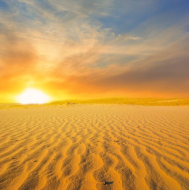 Geniş sıcak kumlu çöl dramatik günbatımında
