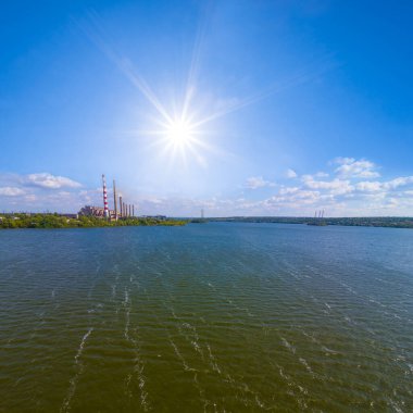 Elektrik santrali yaz güneşli bir günde nehir kıyısında kalır.