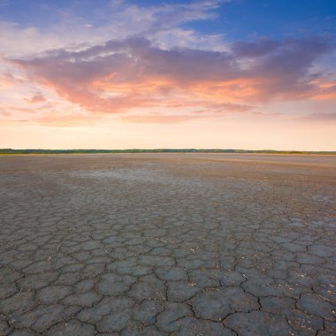 Kuru çatlamış tuzlu su, dramatik günbatımında.