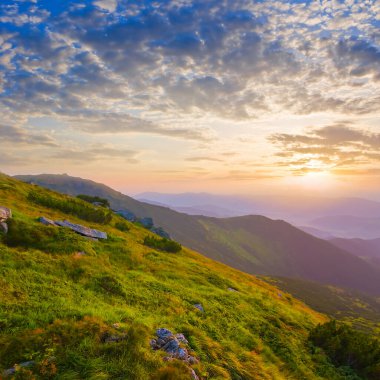 Güneş doğarken mavi sisli yeşil dağ vadisi, sabahın erken saatlerinde yeşil dağ