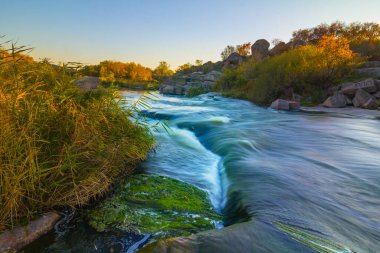 Nehir kanyondaki büyük taşların arasından akıyor.