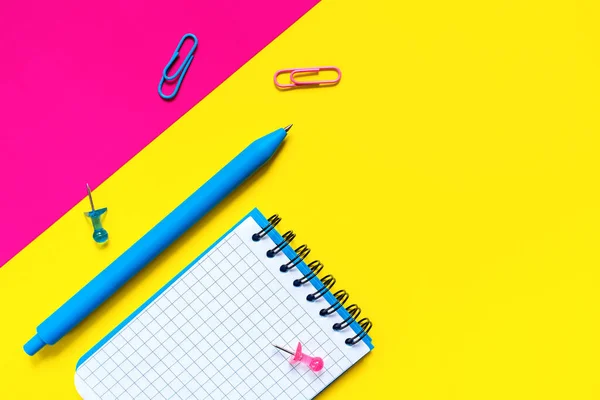 Okul ve ofis malzemelerinin renkleri. Mavi kalem ve boş kağıtlı açık not defteri. Okula ve eğitime dönüş kavramı. Minimalist tasarım. Geometrik stil. Düz yatıyordu. Kopyalama alanı ile.