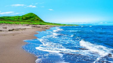 Manzaralı deniz manzarası. Rusya 'nın Sakhalin adasındaki Japon denizinin resimli sahili. Sakhalin, Rusya Federasyonu 'nun en büyük adasıdır. Mavi deniz, yeşil dağ ve açık gökyüzü. Güneşli bir gün.