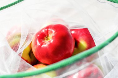 Yeniden kullanılabilir çevre dostu ağ torbasında taze elmalar. Güneşli bir gün. Plastiksiz, sıfır atık ve sürdürülebilir yaşam tarzı konsepti. Tekrar kullanılabilir. Çevresel kaygılar. Yakın görünüm.