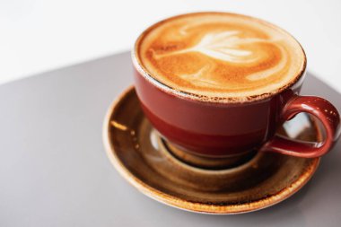 Sabah kahvesi köpüklü seramik bardakta. Aroma taze kapuçino. Bir kafede kahve molası.