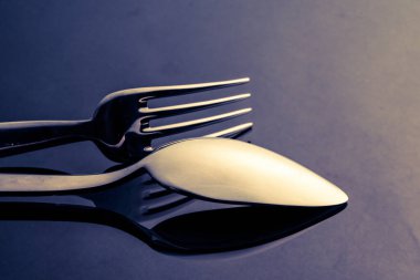Metal kaşık ve çatal masada.