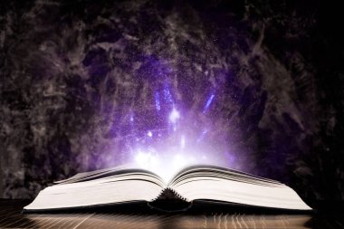 Siyah arkaplanda ışık olan sihirli kitap