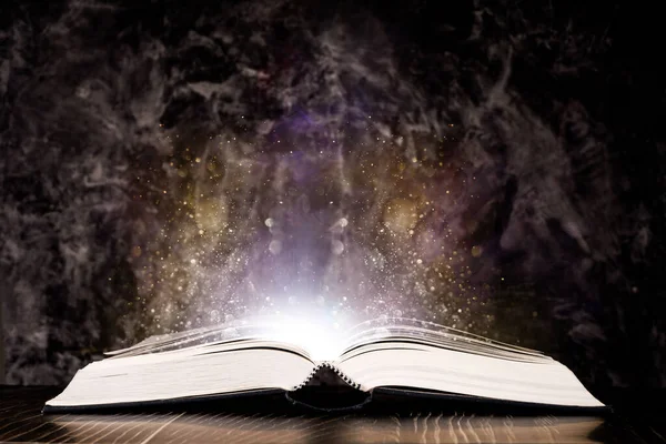 Siyah arkaplanda ışık olan sihirli kitap