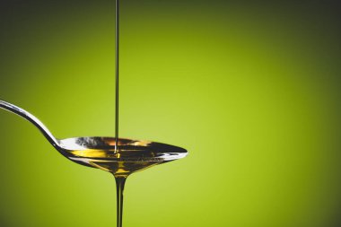 Zeytin yağı kaşığa akıyor.