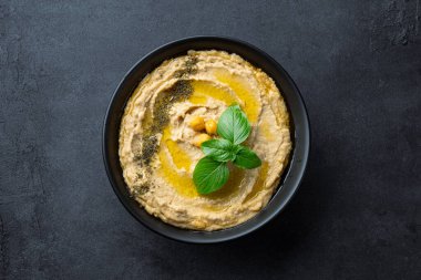 Geleneksel bir yemek veya aperatif humus veya siyah arka planda baba ghanoush.