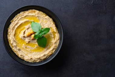 Geleneksel bir yemek veya aperatif humus veya siyah arka planda baba ghanoush.