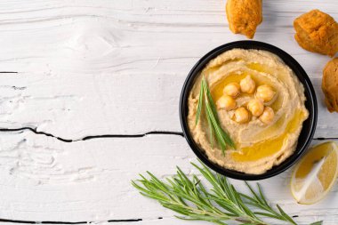 Geleneksel bir yemek veya aperatif humus veya beyaz ahşap arka planda baba ghanoush.