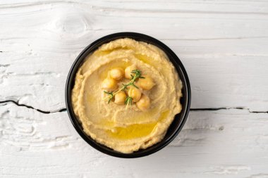 Geleneksel bir yemek veya aperatif humus veya beyaz ahşap arka planda baba ghanoush.