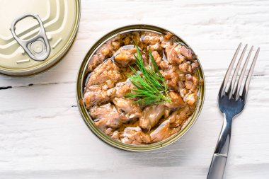 Canned tuna in brine isolated on white wooden background
