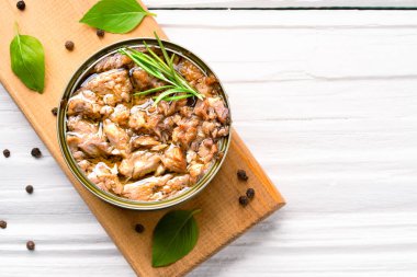 Canned tuna in brine isolated on white wooden background