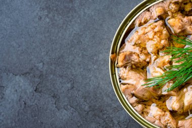 Canned tuna in brine isolated on black background