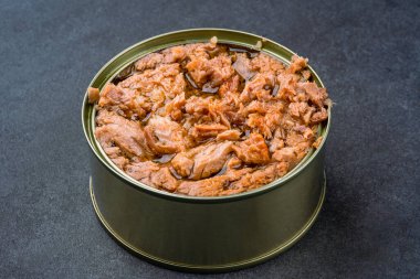 Canned tuna in brine isolated on black background