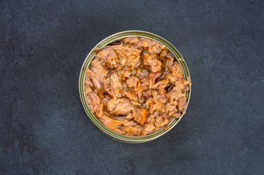 Canned tuna in brine isolated on black background