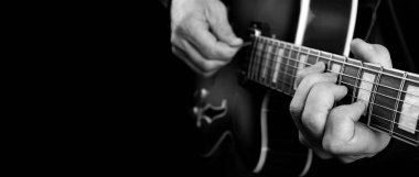 Gitarist elleri ve gitarist elleri yakın çekim. Elektro gitar çalıyor. Boşlukları kopyala. siyah ve beyaz.