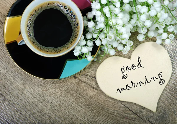 good morning. morning coffee and lily of the valley flower on a wooden table.