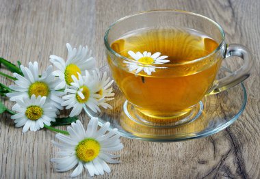 ahşap bir masa üzerinde papatya çayı fincan