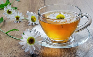 ahşap bir masa üzerinde papatya çayı fincan