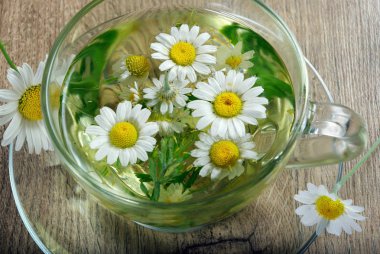 ahşap bir masa üzerinde papatya çayı fincan. Bitkisel vitamin çay. üstten görünüm.