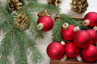 Ahşap masa ve çam dalları üzerinde kırmızı Noel topları. kopya alanlarda.