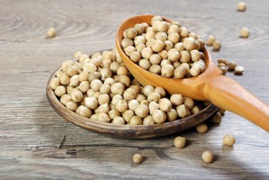 ahşap bir masa üzerinde bir tahta kaşık nohut