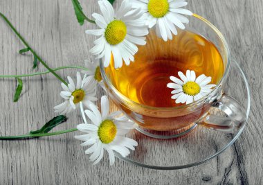 ahşap bir masa üzerinde papatya çayı fincan. üstten görünüm.