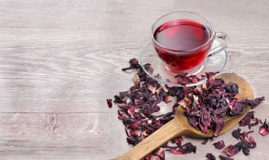 Hibiscus çay içinde gül yaprakları ve kuru çay arasında ahşap bir masa cam bardakta. üstten görünüm. Vitamini çay soğuk algınlığı ve grip için.