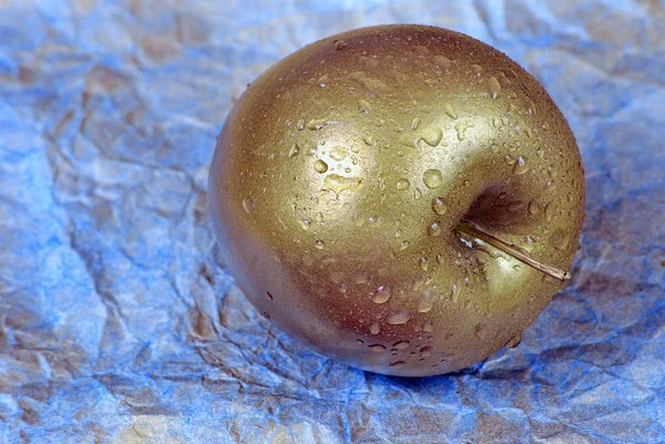 Goldener Apfel Mit Tautropfen Auf Blauem Hintergrund Nahaufnahme — Stockfoto